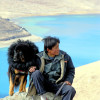 Scenic view of Tibet with a man and his Do Khyi pet